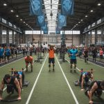 Athlètes en compétition à l'HYROX Paris, alternant course et stations d'entraînement fonctionnel.
