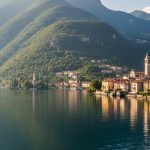 Vue pittoresque du lac d'Orta avec le village d'Orta San Giulio et des montagnes verdoyantes.
