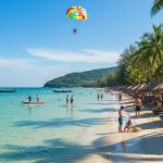 Plage de Chaweng à Koh Samui, ambiance animée avec baigneurs et activités nautiques.