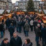 Marché de Noël en Alsace avec stands illuminés et visiteurs dégustant des spécialités locales.