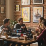 Passionnés de cinéma discutant autour d'une table avec des affiches de films en arrière-plan.